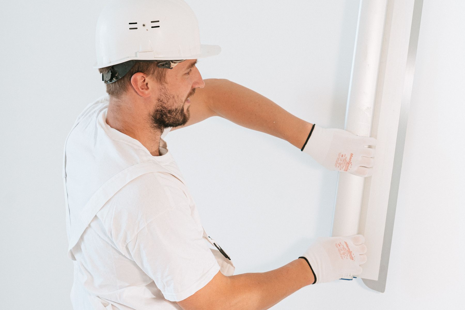 Craftsperson preparing a wall surface for a smooth finish