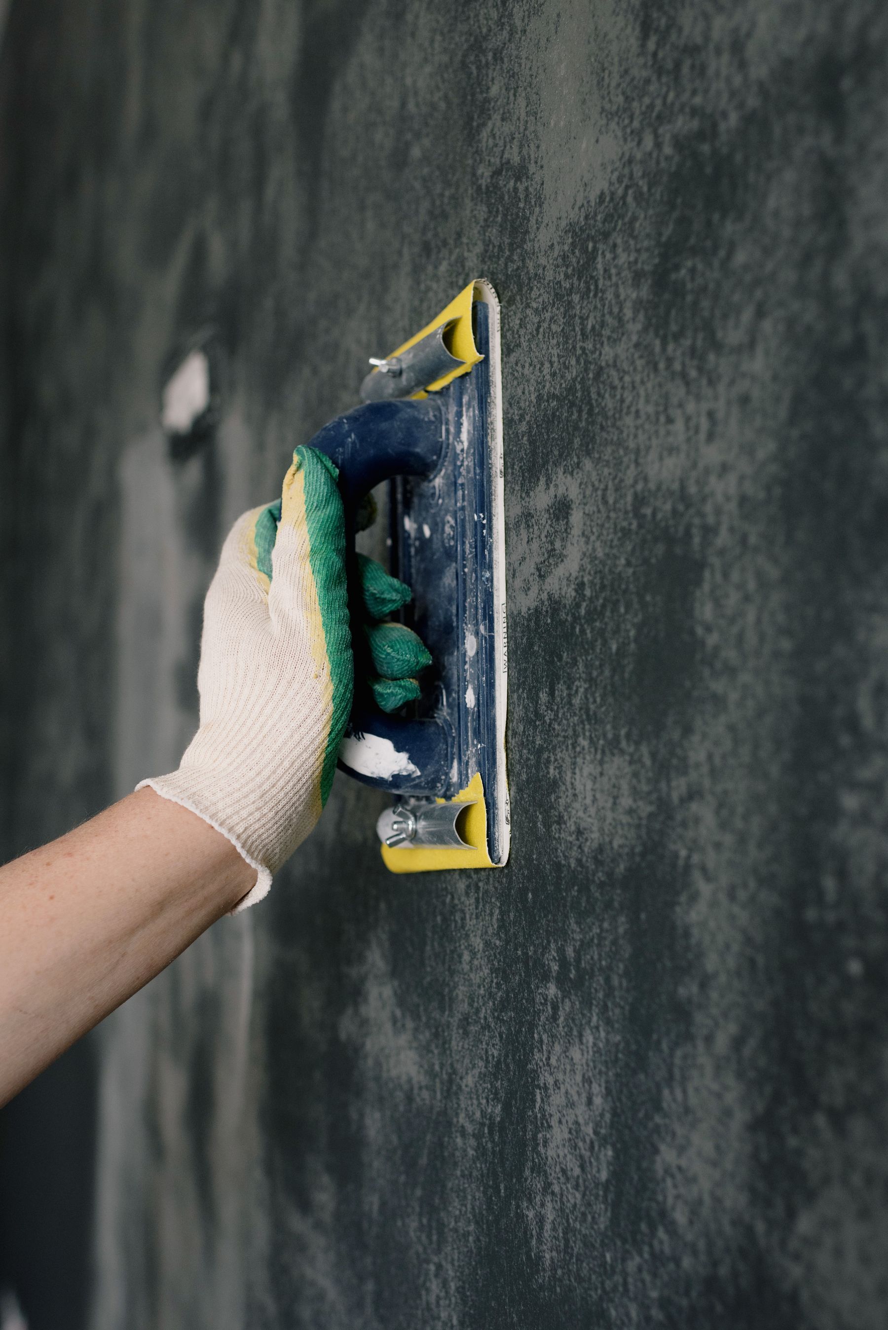 Craftsperson preparing a wall surface for a smooth finish